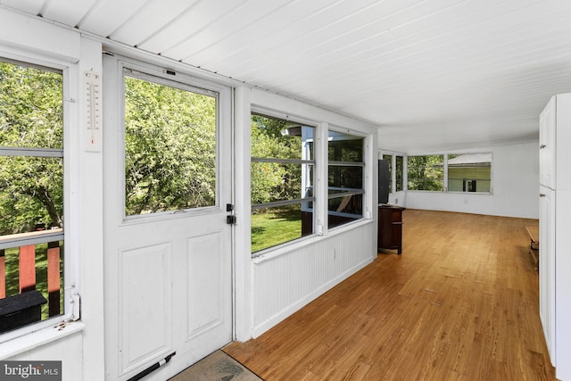 unfurnished sunroom with plenty of natural light and wood finished floors
