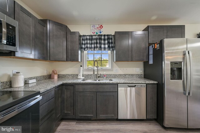 15 Mayflower Dr, Felton, DE 19943 - kitchen featuring light wood-style floors, appliances with stainless steel finishes, light stone counters, and a sink