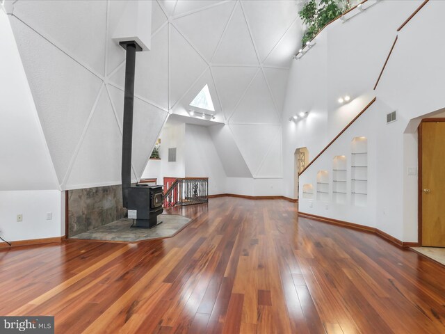 11035 Bennie Duncan Rd, Frederick, MD 21701 - additional living space with a wood stove, hardwood / wood-style flooring, baseboards, high vaulted ceiling, and built in shelves