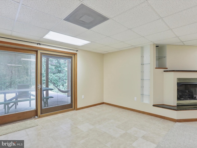 11035 Bennie Duncan Rd, Frederick, MD 21701 - unfurnished living room featuring a paneled ceiling, baseboards, a fireplace with raised hearth, and built in shelves