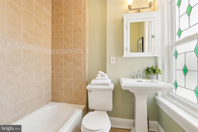 bathroom with baseboards, toilet, and shower / bath combination