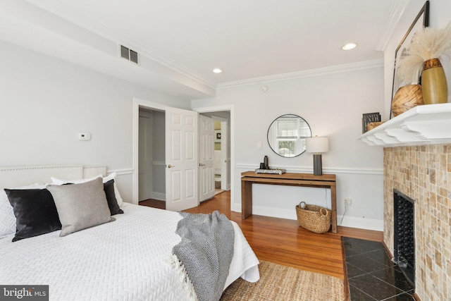 bedroom featuring a tile fireplace, visible vents, recessed lighting, and ornamental molding