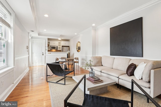 living room featuring baseboards, light wood-type flooring, crown molding, and recessed lighting