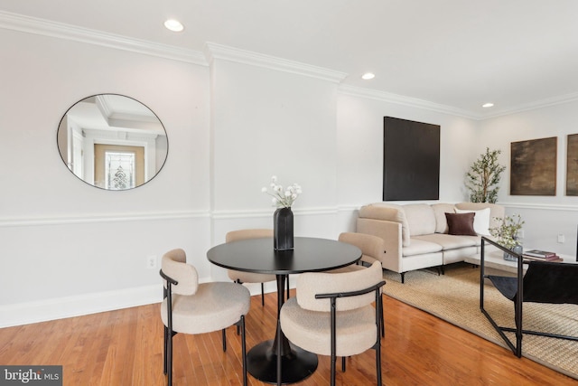 dining space featuring crown molding, recessed lighting, and wood finished floors