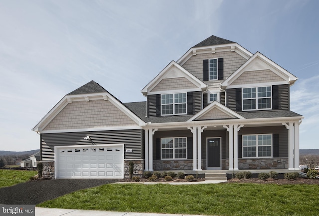 craftsman house with covered porch, a garage, stone siding, and aphalt driveway