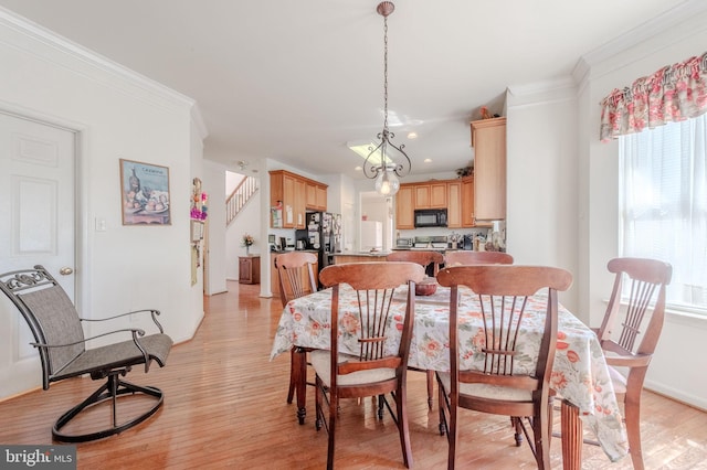 dining area featuring baseboards, a notable chandelier, ornamental molding, and light wood-type flooring