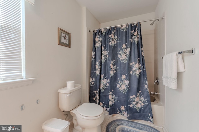 full bath with tile patterned floors, shower / bath combination with curtain, and toilet