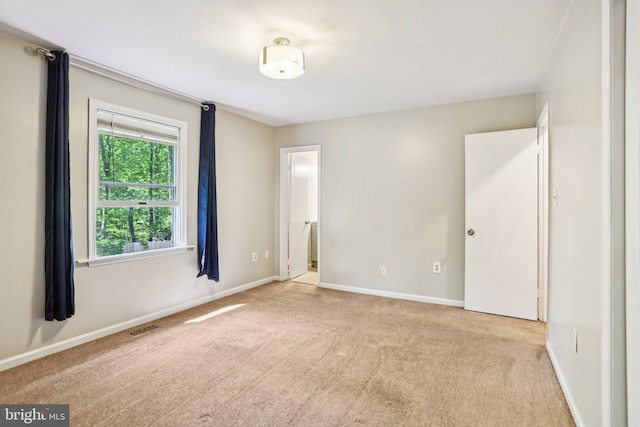 carpeted spare room with visible vents and baseboards