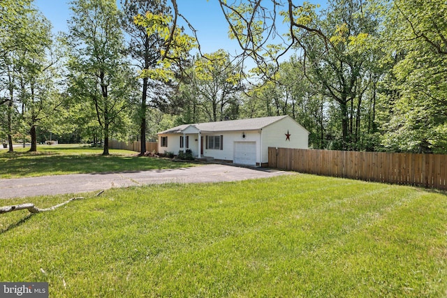 view of front of property featuring an attached garage, fence, aphalt driveway, and a front lawn