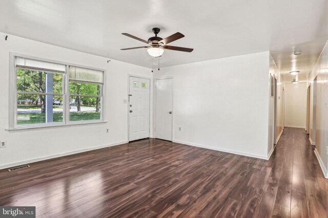 unfurnished living room featuring wood finished floors, visible vents, a ceiling fan, and baseboards