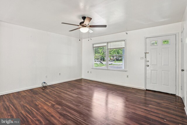 interior space featuring wood finished floors, visible vents, baseboards, and ceiling fan