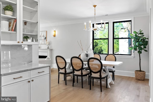 dining space featuring a chandelier, light wood-type flooring, a healthy amount of sunlight, and baseboards