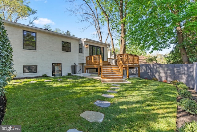 back of house featuring brick siding, a deck, stairway, and fence