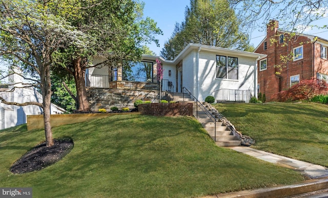 view of front of home with stairway, brick siding, and a front yard