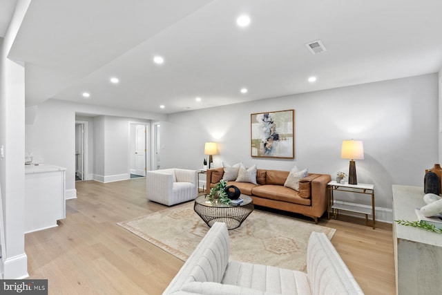 living room featuring light wood-style flooring, baseboards, and recessed lighting