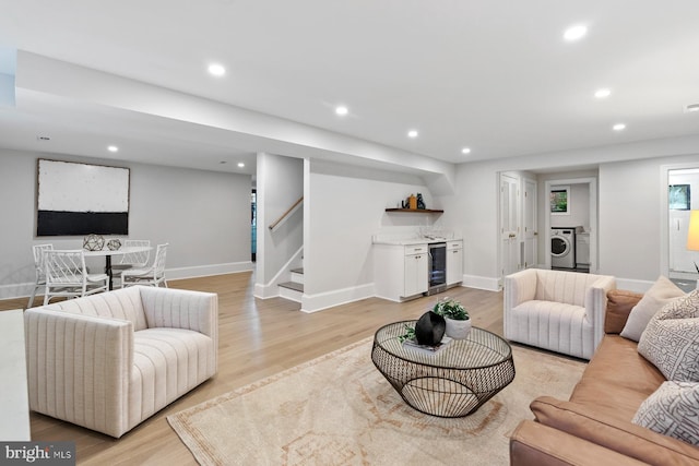 living room featuring wine cooler, bar, recessed lighting, and washer / dryer