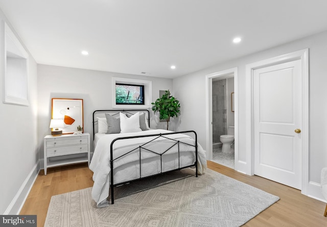 bedroom featuring baseboards, ensuite bathroom, wood finished floors, and recessed lighting
