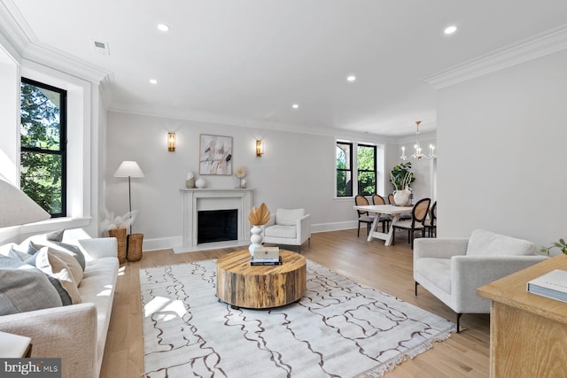 living room with a fireplace with flush hearth, recessed lighting, visible vents, ornamental molding, and a chandelier