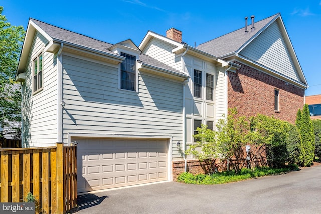 1448 Ingleside Ave, Mclean, VA 22101 - view of home's exterior with a chimney, driveway, a garage, and brick siding