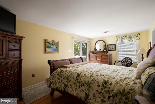 bedroom with baseboards and wood finished floors