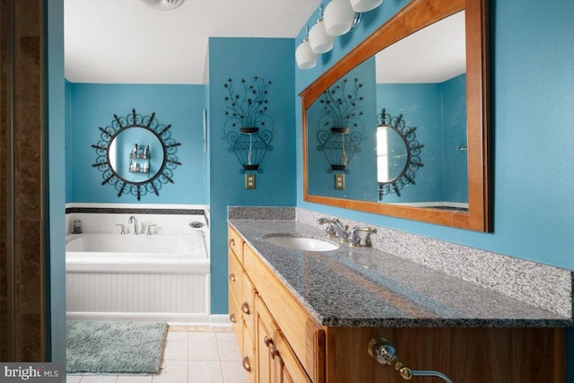 bathroom featuring tile patterned flooring, a bath, and vanity