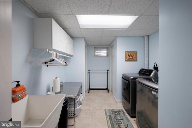 laundry area with cabinet space, independent washer and dryer, and light tile patterned flooring