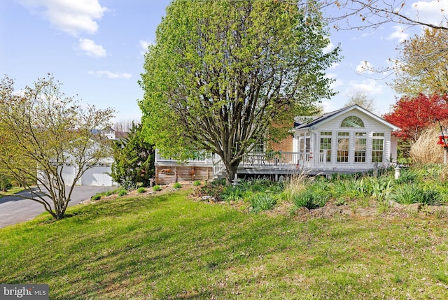 view of yard featuring driveway and a deck