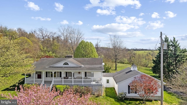 rear view of house with a porch and a chimney