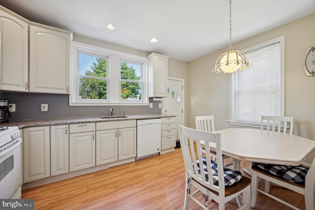 kitchen featuring pendant lighting, an inviting chandelier, white appliances, light wood-type flooring, and a sink