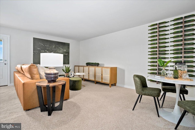 carpeted living area featuring baseboards