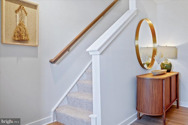 stairs featuring wood finished floors and baseboards