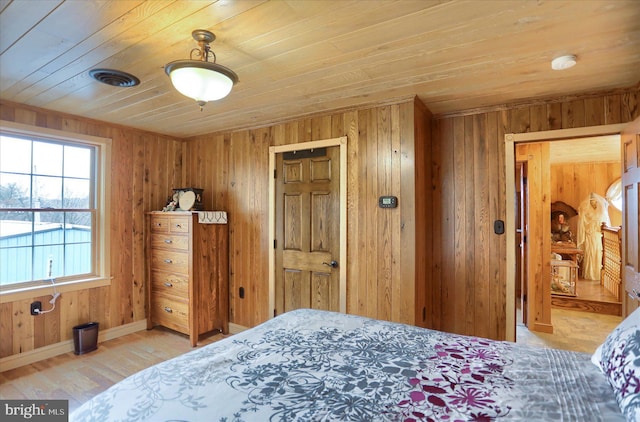 bedroom with wood ceiling, wooden walls, wood finished floors, and baseboards