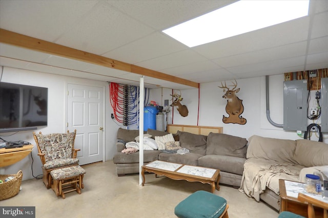 living area featuring electric panel, a paneled ceiling, and concrete floors