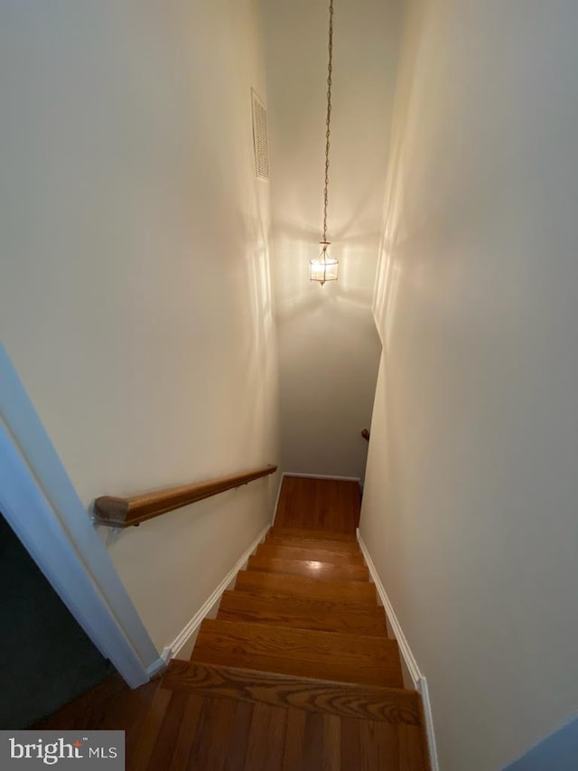 staircase with wood finished floors and baseboards