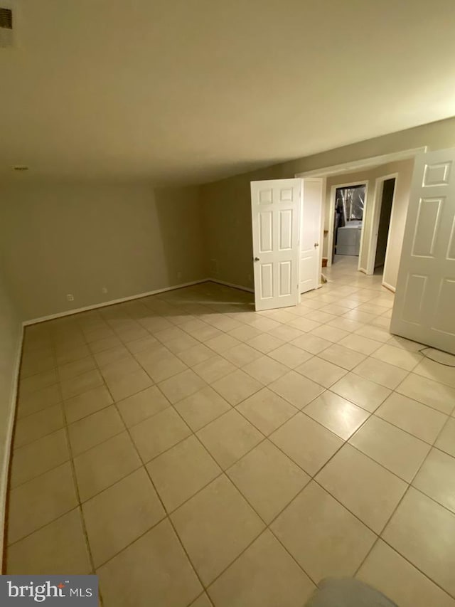 spare room with light tile patterned floors and baseboards