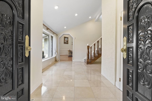 foyer entrance with light tile patterned floors, vaulted ceiling, recessed lighting, stairs, and baseboards