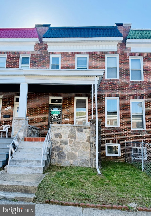 view of property featuring brick siding and a porch