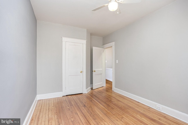 unfurnished bedroom featuring light wood-style flooring, baseboards, and a ceiling fan