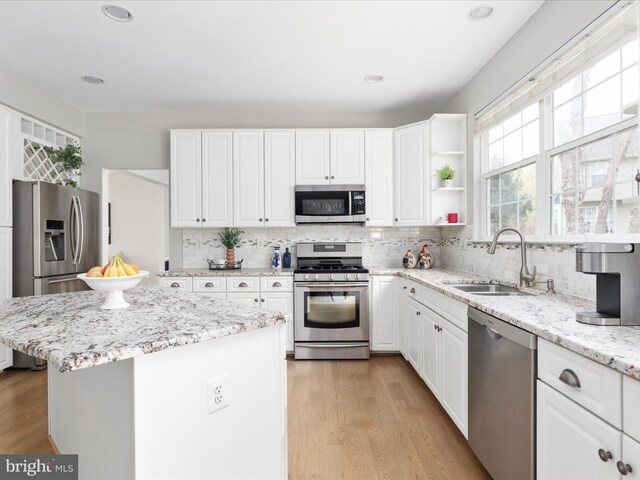 kitchen featuring a sink, tasteful backsplash, white cabinetry, and stainless steel appliances