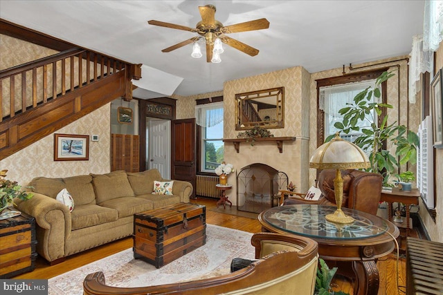 6626 Jefferson Blvd, Frederick, MD 21703 - living room with radiator, wallpapered walls, wood finished floors, a fireplace, and ceiling fan