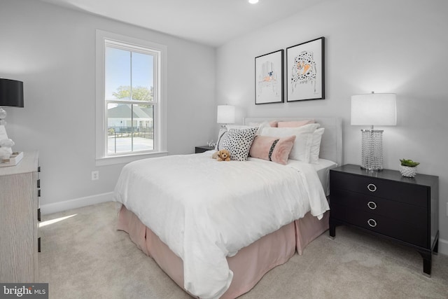 bedroom with light carpet and baseboards