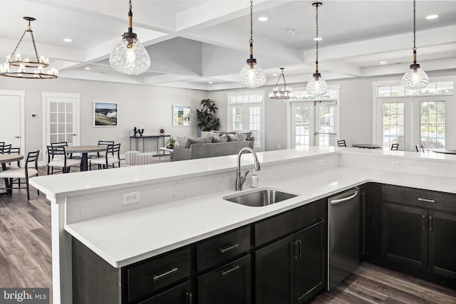 kitchen featuring a sink, light countertops, coffered ceiling, and dark wood finished floors