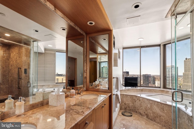 bathroom featuring a shower stall, a bath, double vanity, and a sink