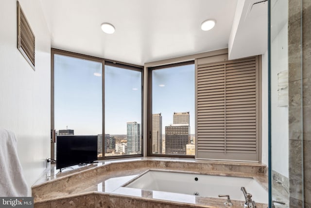 full bath with a garden tub and visible vents