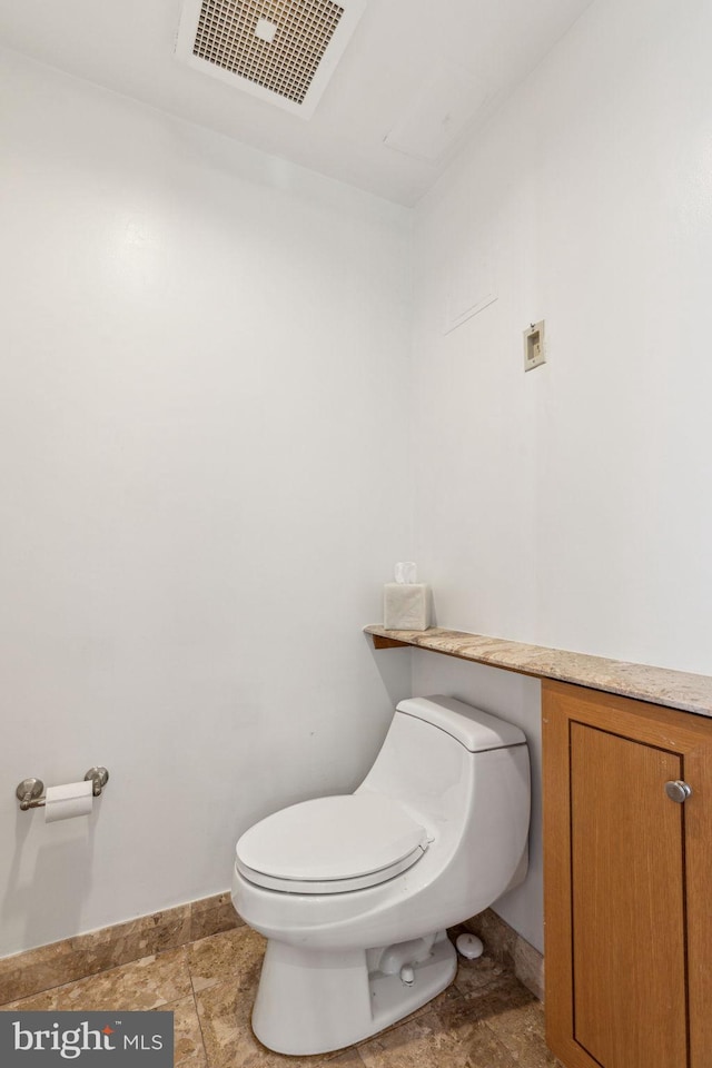 bathroom with toilet, baseboards, and visible vents