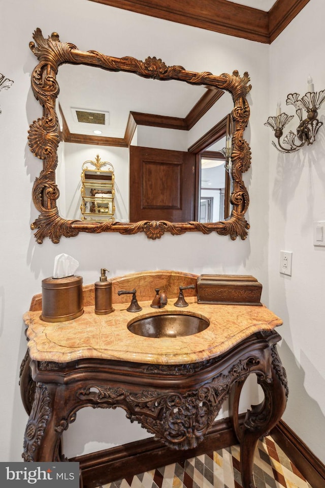 bathroom featuring vanity, visible vents, baseboards, and ornamental molding