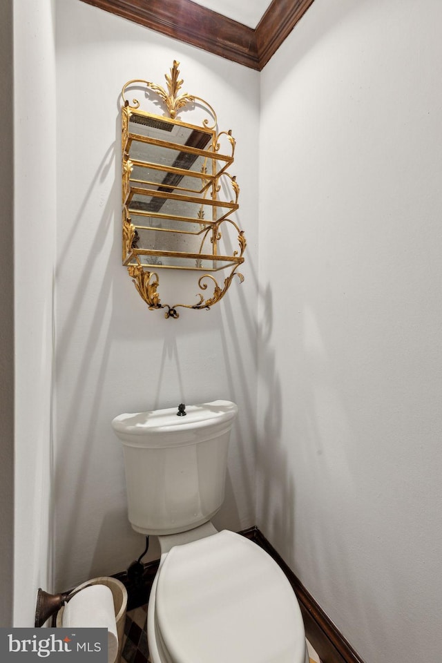 bathroom featuring ornamental molding and toilet