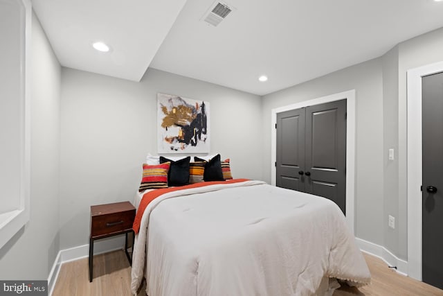bedroom featuring wood finished floors, baseboards, and recessed lighting