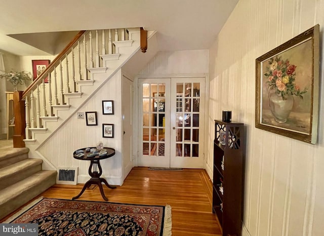interior space with stairs, french doors, wood finished floors, and visible vents