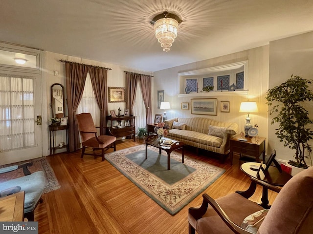 living room with an inviting chandelier and wood finished floors